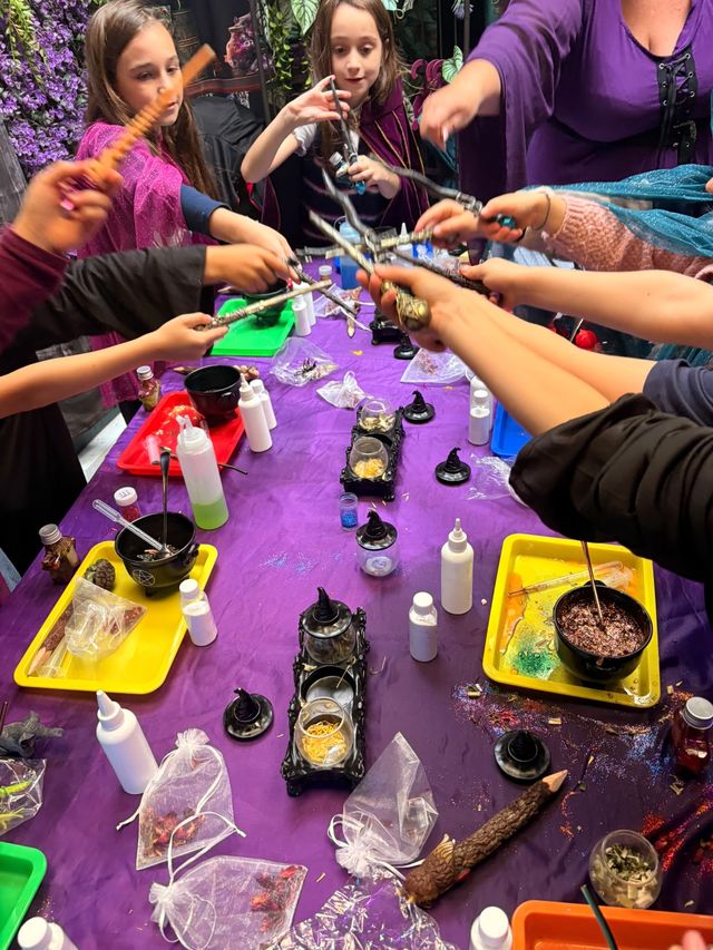 Wands raised together over the potion table