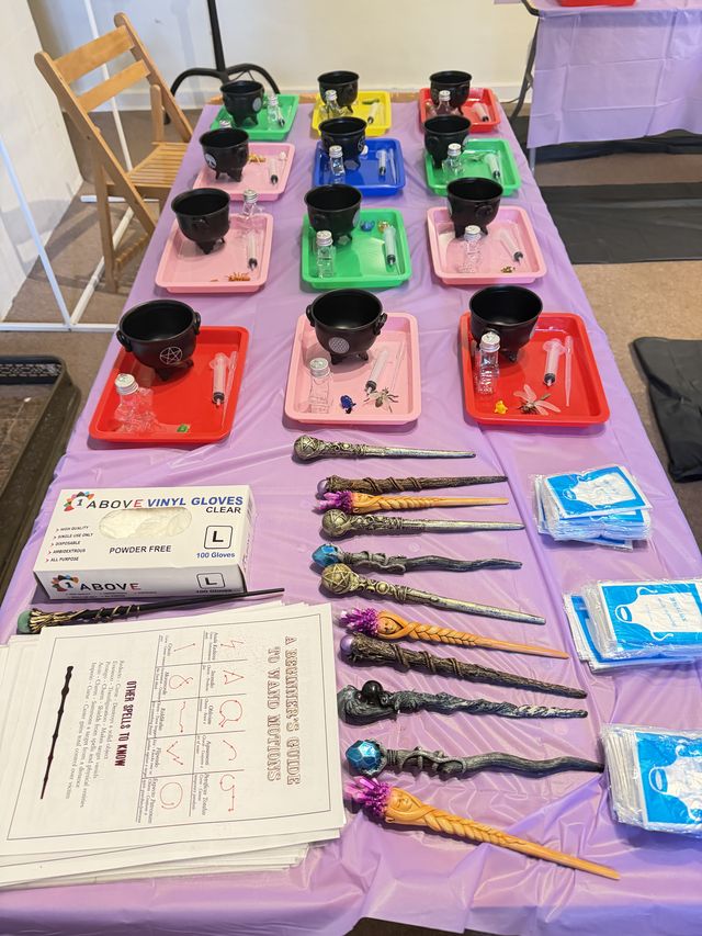 A table set with wands, cauldrons and trays