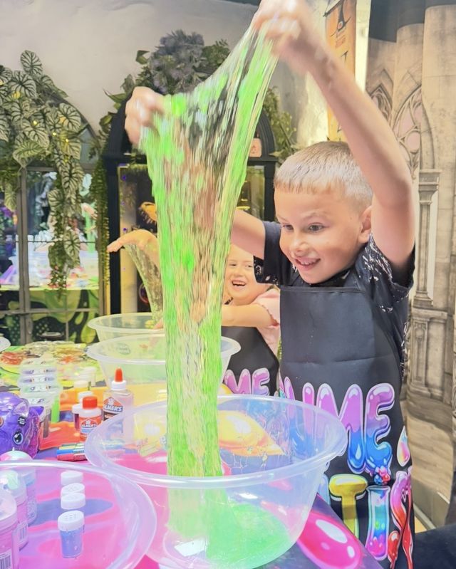 A boy stretching a long string of bright green slime