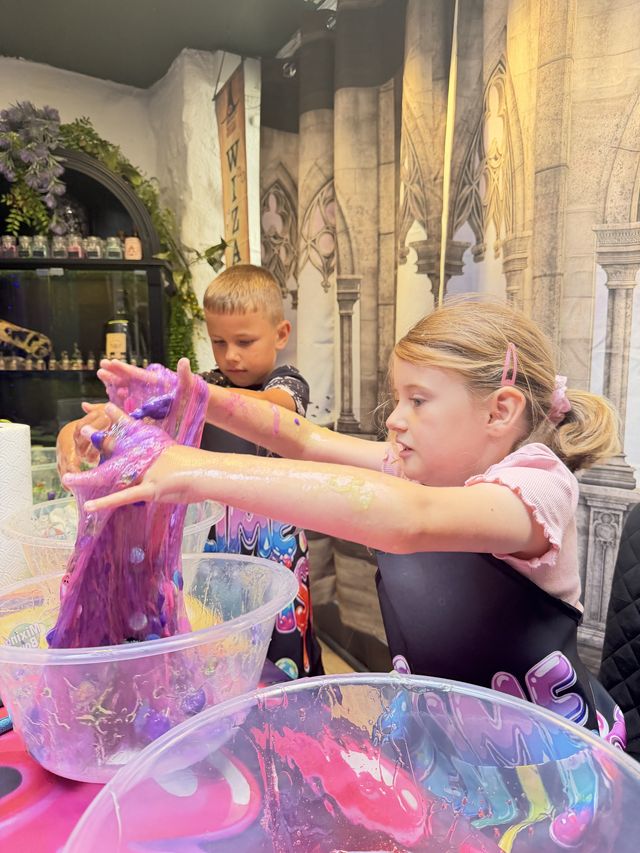 Two children stretching purple slime