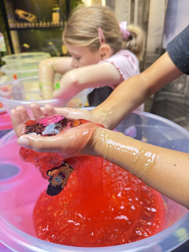 Hands holding a pool of glossy red slime