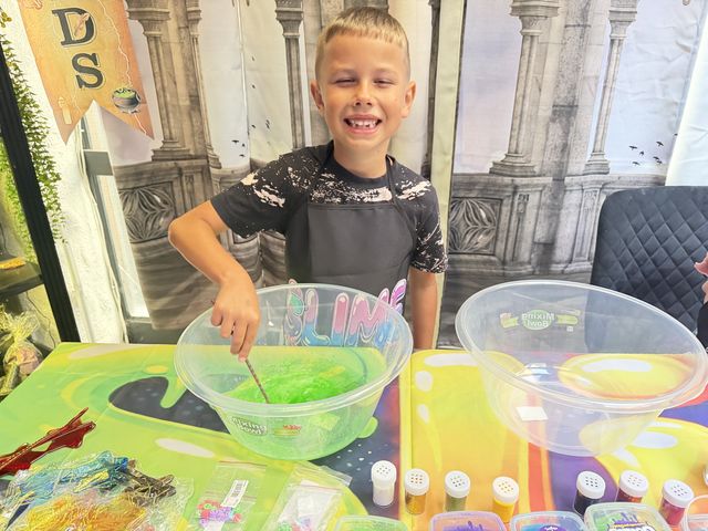 A boy smiling over his bowl of green slime