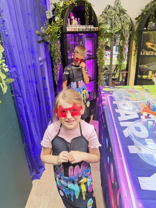 A girl in heart-shaped sunglasses at a slime party