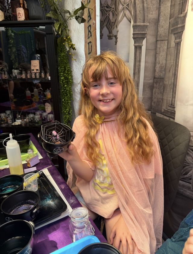 A girl in a pink cape holding her finished potion