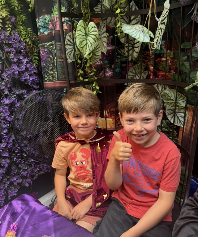 Two boys giving a thumbs up at the potion table