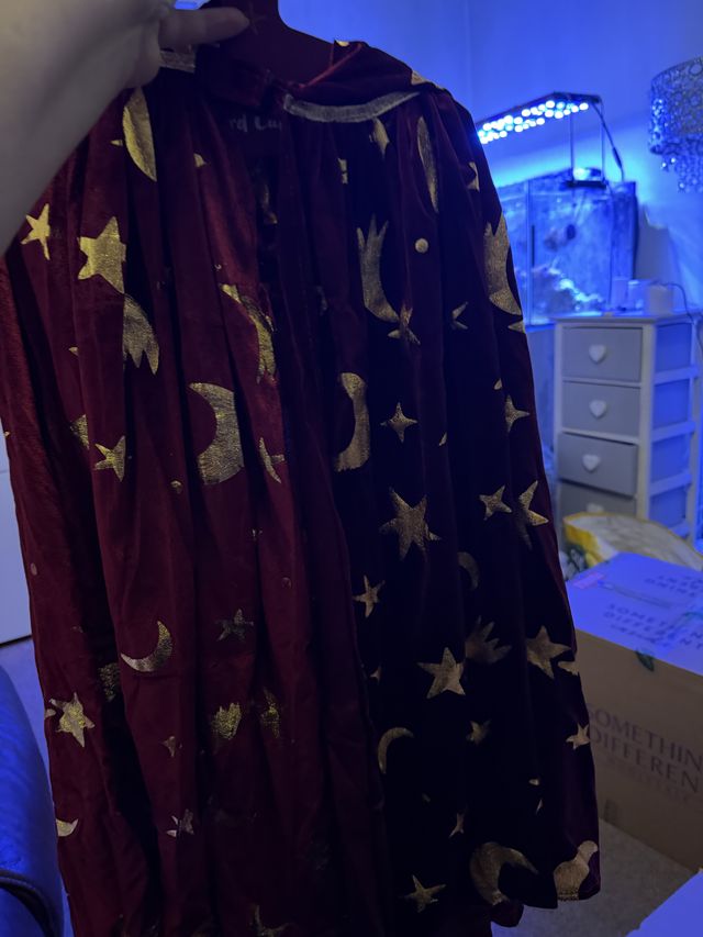 A red wizard cape covered in stars and moons