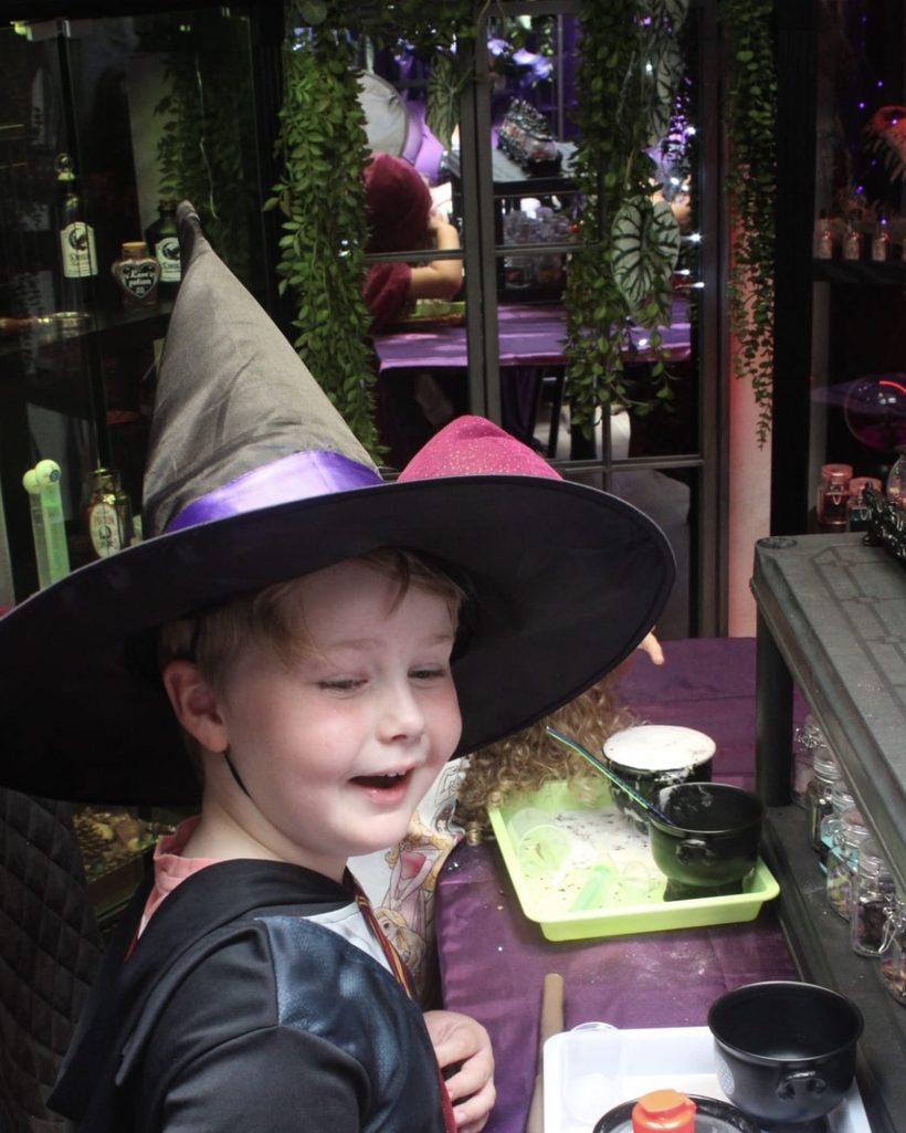 A witch hat and Halloween treats laid out on the party table